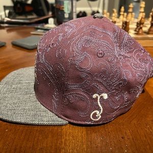 Purple and grey Grassroots hat designed by Randall Robert’s.